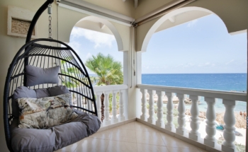 Hanging chair on terrace at marvelous three bedroom penthouse apartment named Dolphin Paradise by Curacao Luxury Holiday Rentals
