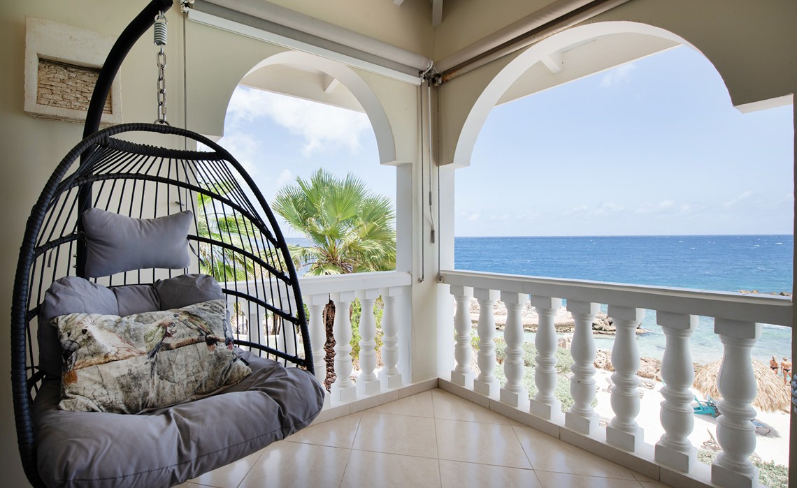 Hanging chair on terrace at marvelous three bedroom penthouse apartment named Dolphin Paradise by Curacao Luxury Holiday Rentals