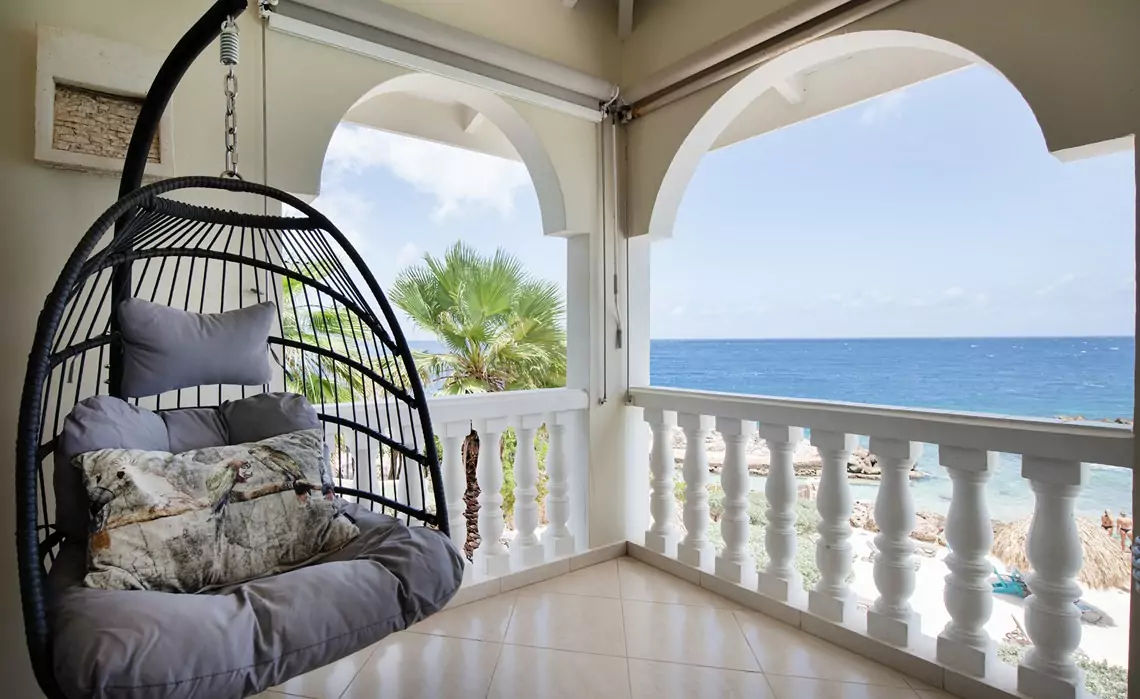 Hanging chair on terrace at marvelous three bedroom penthouse apartment named Dolphin Paradise by Curacao Luxury Holiday Rentals