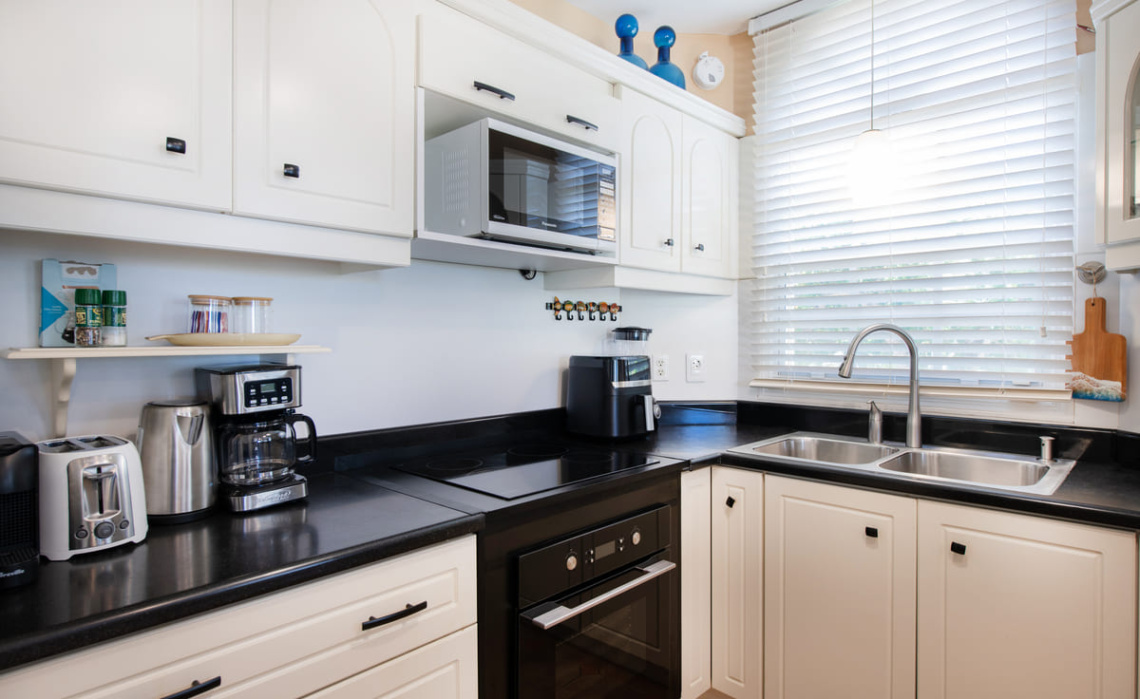 Kitchen of the Portofino two‑bedroom apartment, fully equipped with refrigerator/freezer, dishwasher, oven, cooktop, microwave, air‑fryer, electric kettle and Nespresso coffee machine.