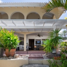 View of the Portofino two‑bedroom ground‑floor apartment from the private tropical garden