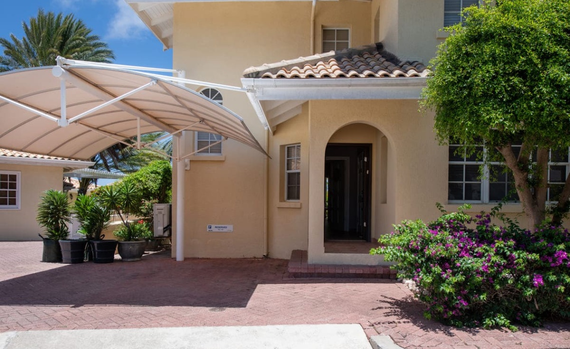 Front entrance of the gated Curacao Ocean Resort building where the Portofino two‑bedroom apartment is located, showing the tropical architecture and resort signage.